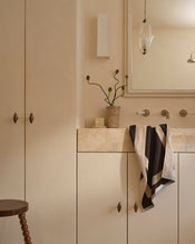 Neutral bathroom with cotton terry hand towel in oatmeal and charcoal hanging near sink. - view