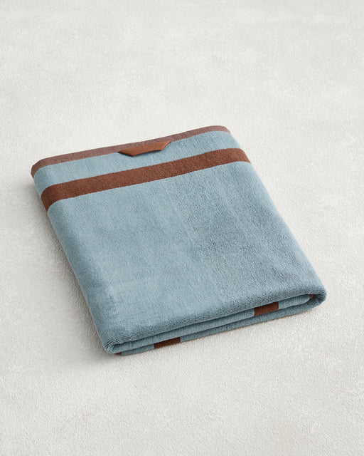The Bed Threads Cacao & Lagoon Two-Toned 100% Cotton Terry Bath Sheet features plush, quick-drying cotton in light blue with brown stripes—ideal for a stylish and practical addition to your bath routine.