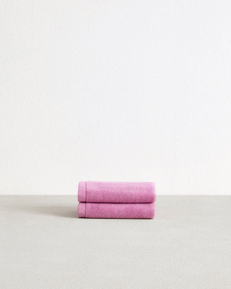 A set of two Bed Threads Bubblegum 100% Cotton Terry Face Washers, soft and gentle on skin, are neatly folded and displayed on a light gray surface with a plain white background.