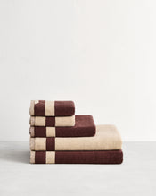 Stack of cotton terry bath towels in reversible colours creme and cacao.  - view