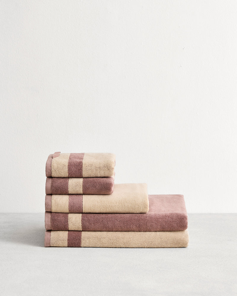Stack of cotton terry towels in reversible colours lavender & creme.