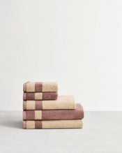 Stack of cotton terry towels in reversible colours lavender & creme. - view