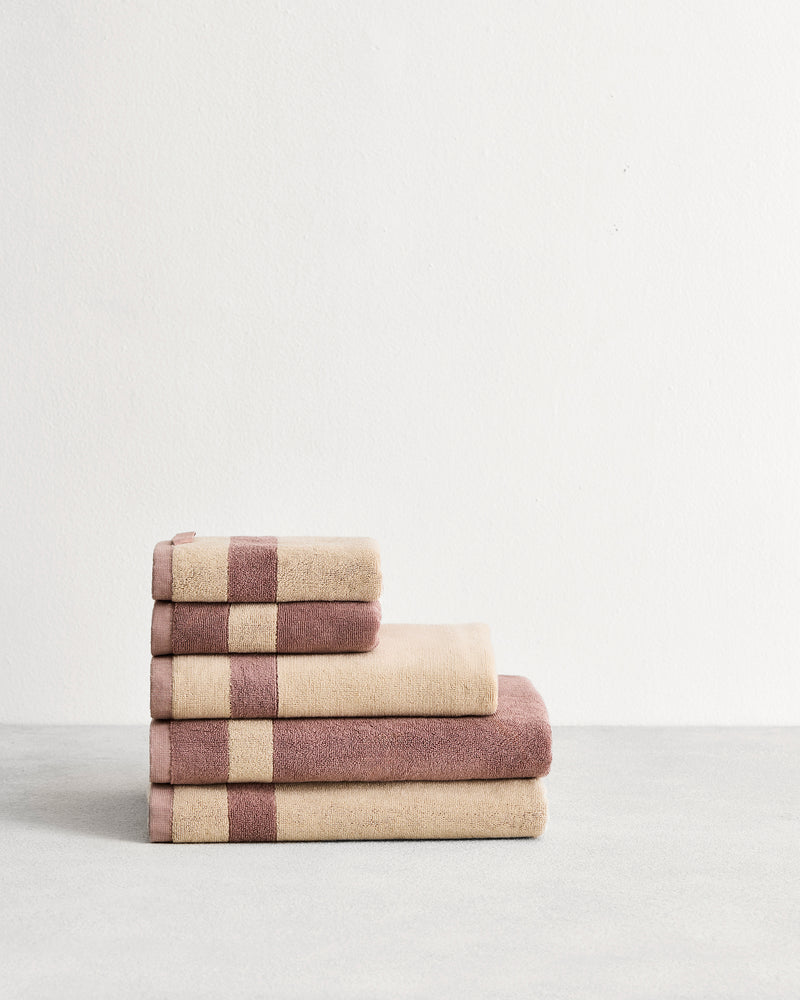 Stack of cotton terry towels in reversible colours lavender & creme.