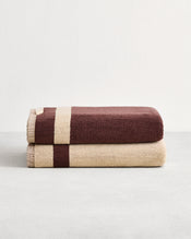 Stack of two cotton terry bath towels in reversible colours creme and cacao.  - view