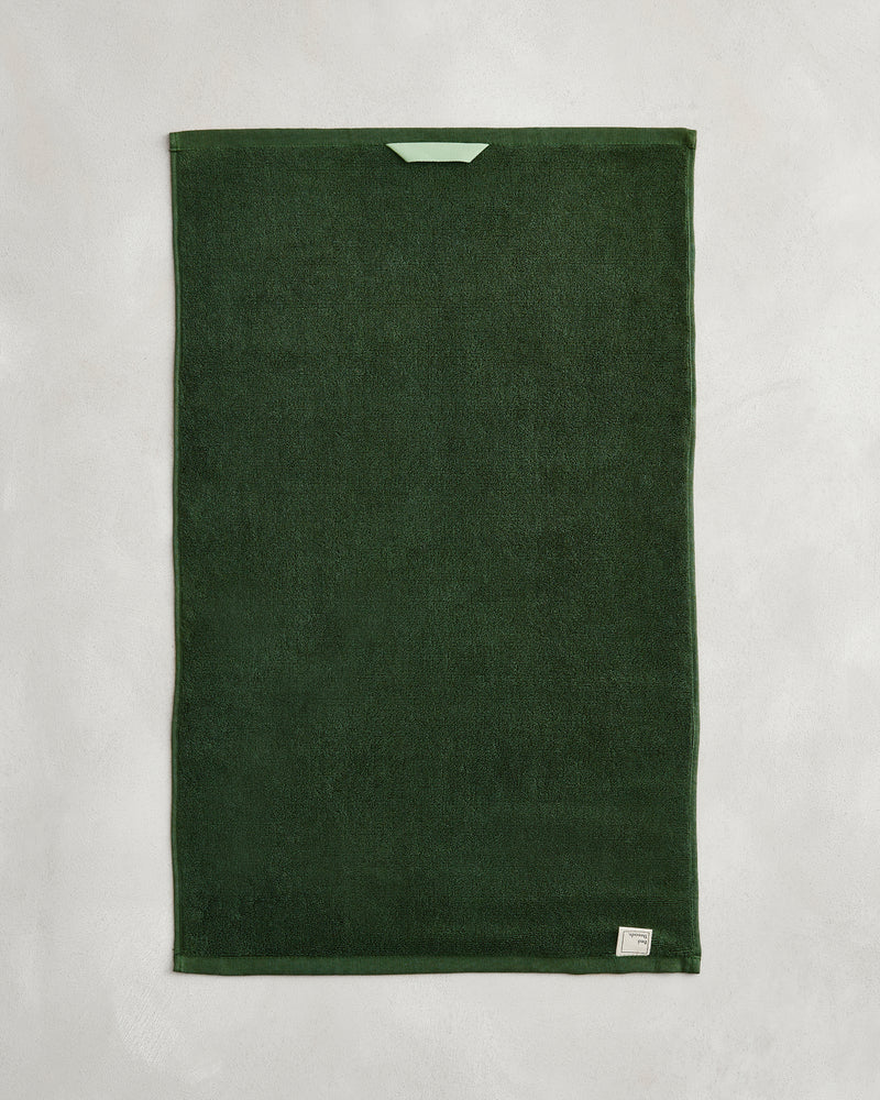 A set of two Moss 100% Cotton Terry Hand Towels by Bed Threads is shown flat on a light gray surface, featuring a small light green loop near one edge and a white label in one corner.